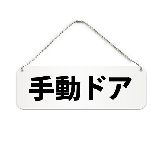 手動ドア と書かれた横長プレート看板（白いアクリル板・黒文字）