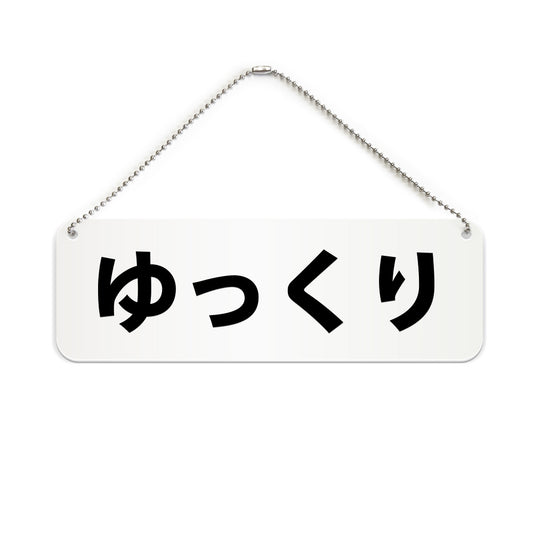 ゆっくり と書かれた横長プレート看板（白いアクリル板・黒文字）