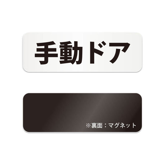 手動ドア と書かれた横長マグネット看板（白いアクリル板・黒文字）