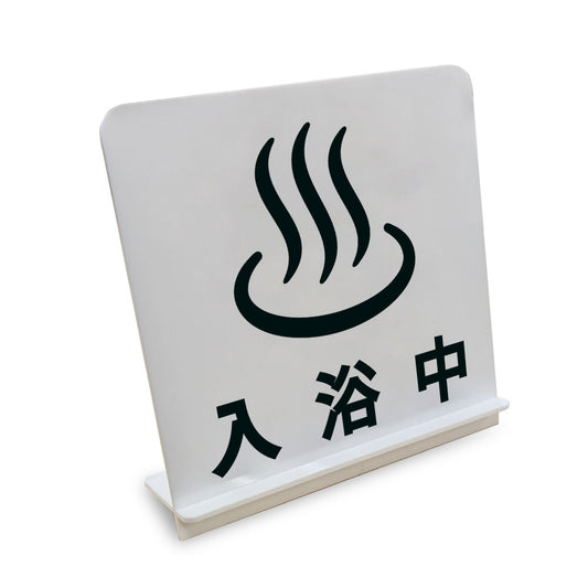 入浴中 と書かれたスタンド看板（白いアクリル板・黒文字）