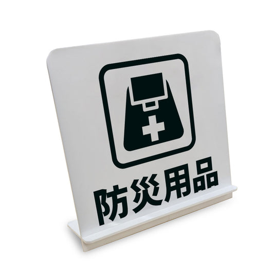 防災用品 と書かれたスタンド看板（白いアクリル板・黒文字）