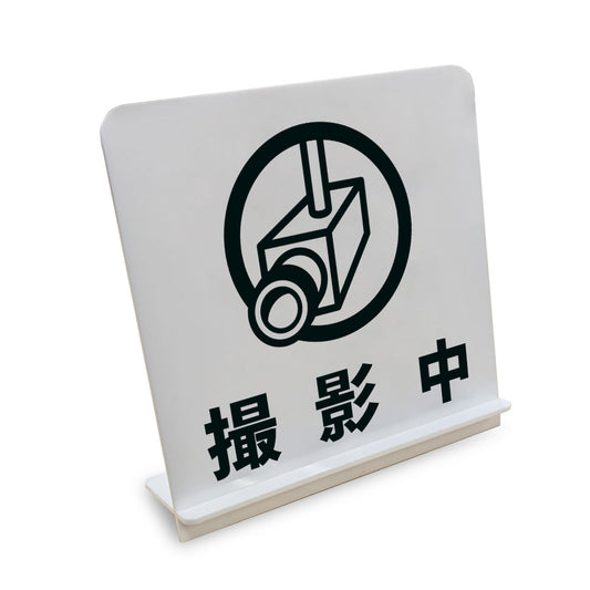 撮影中 と書かれたスタンド看板（白いアクリル板・黒文字）