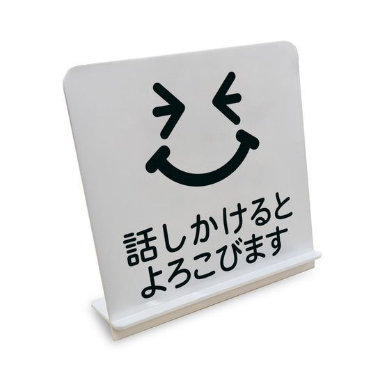 話かけるとよろこびます と書かれたスタンド看板（白いアクリル板・黒文字）