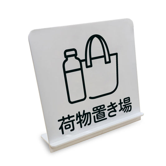 荷物置き場 と書かれたスタンド看板（白いアクリル板・黒文字）