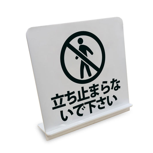 立ち止まらないで下さい と書かれたスタンド看板（白いアクリル板・黒文字）