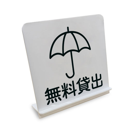無料貸出 かさ と書かれたスタンド看板（白いアクリル板・黒文字）