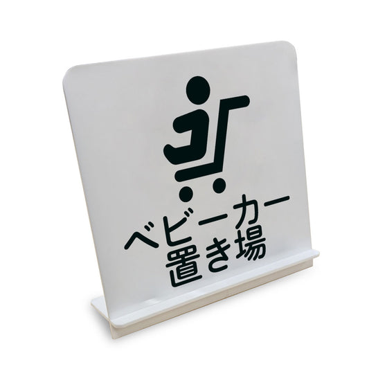ベビーカー置き場 と書かれたスタンド看板（白いアクリル板・黒文字）