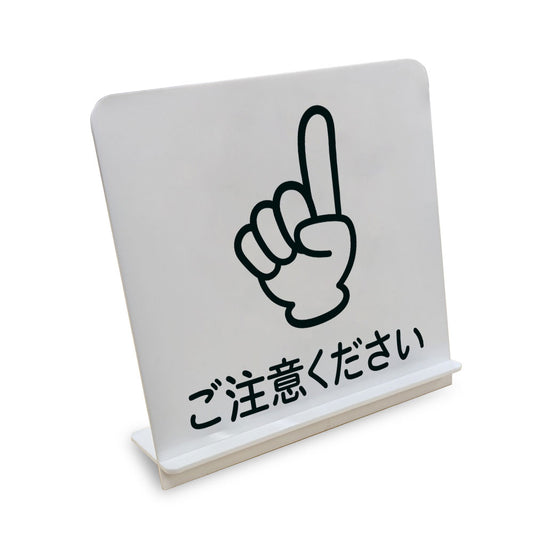 ご注意ください 上 と書かれたスタンド看板（白いアクリル板・黒文字）