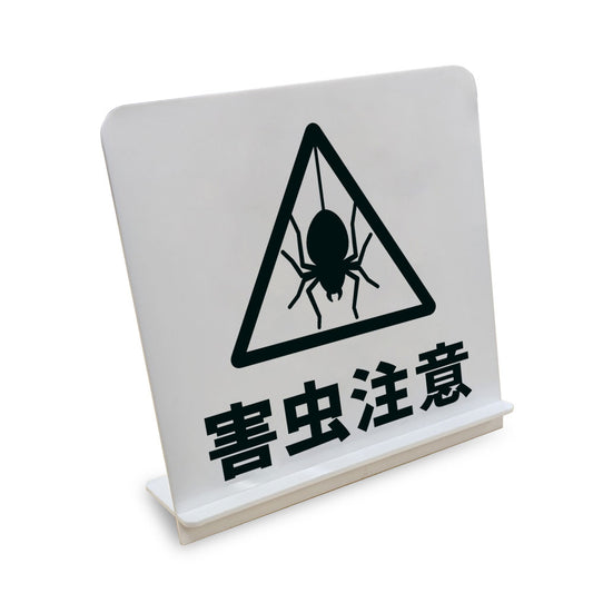 害虫注意 クモ と書かれたスタンド看板（白いアクリル板・黒文字）