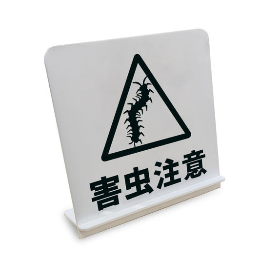 害虫注意 ムカデ と書かれたスタンド看板（白いアクリル板・黒文字）