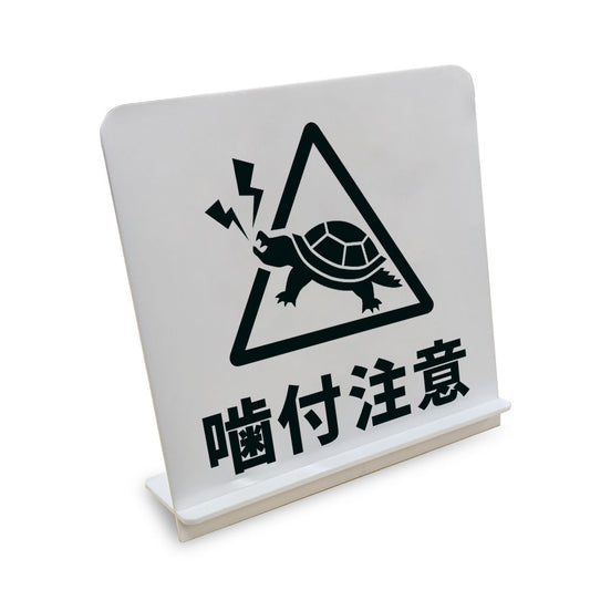 噛付注意 カメ と書かれたスタンド看板（白いアクリル板・黒文字）
