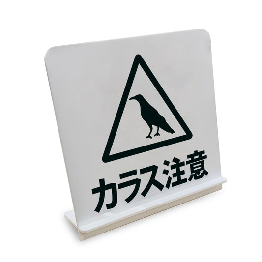 カラス注意 と書かれたスタンド看板（白いアクリル板・黒文字）