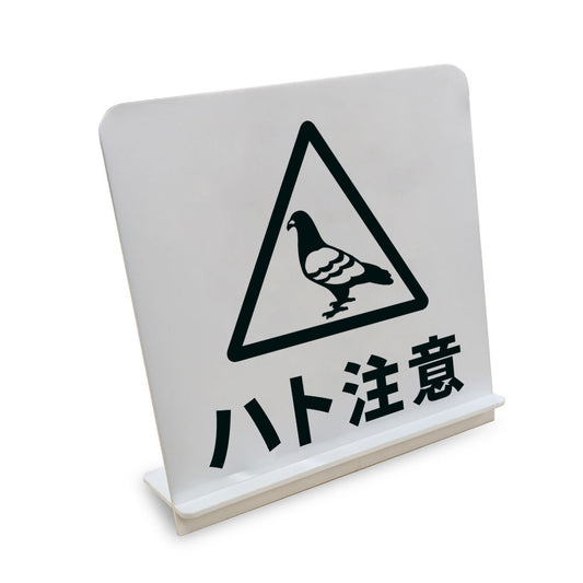 ハト注意 と書かれたスタンド看板（白いアクリル板・黒文字）